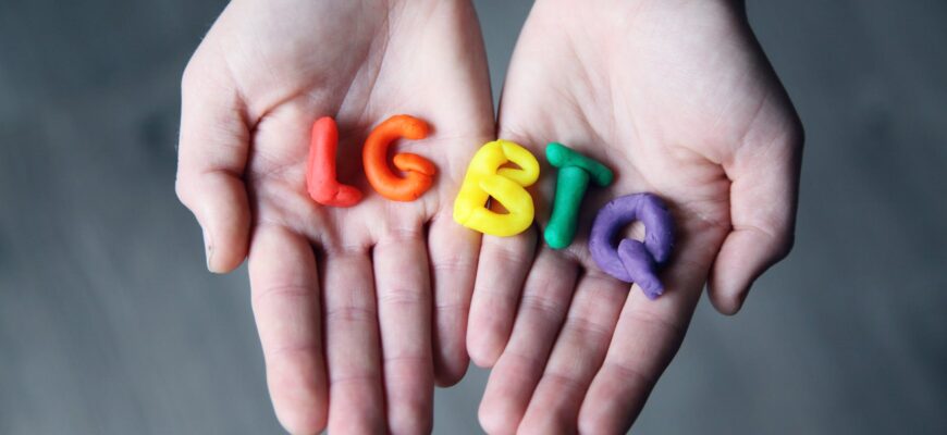 close up photo of lgbtq letters on a person s hands