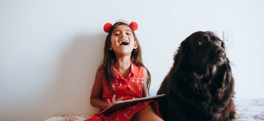 happy girl sitting beside black dog