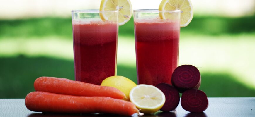 carrot fruit beside lemon fruit on black wooden table