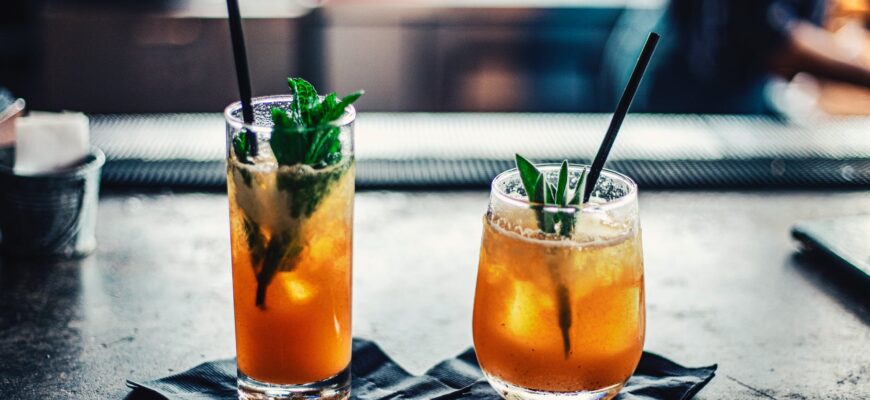 two brown liquid inside clear drinking glasses