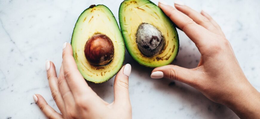 person holding sliced avocado