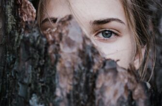 calm woman behind tree bark in park