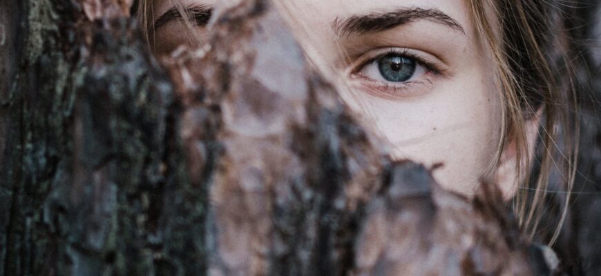 calm woman behind tree bark in park