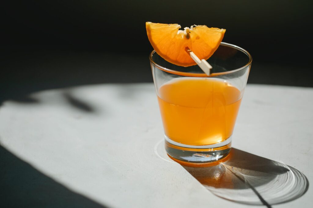 glass of orange cocktail on table