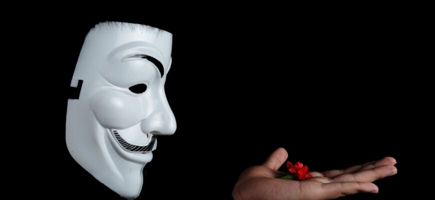 guy fawkes mask and red flower on hand