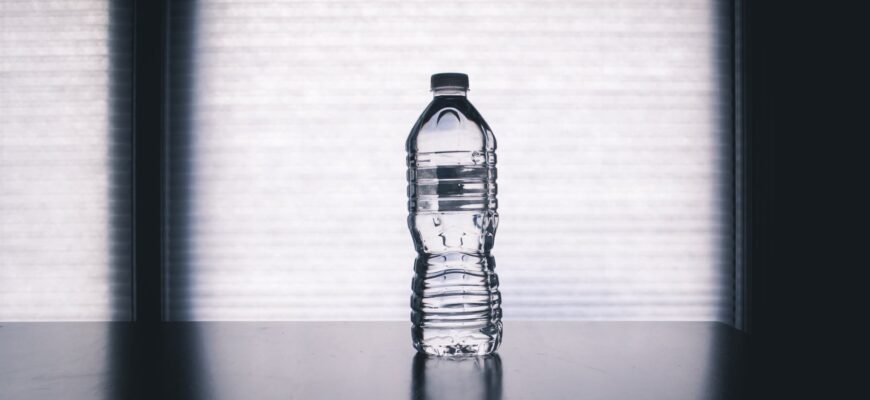 clear disposable bottle on black surface