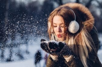 woman blowing snow from hand