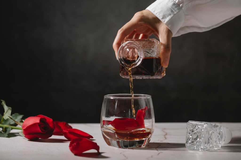 crop person pouring whiskey into glass