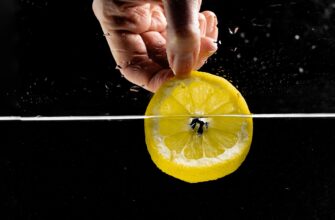 hand of a person dipping sliced lemon in water