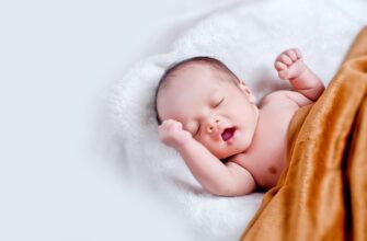 baby lying on white fur with brown blanket