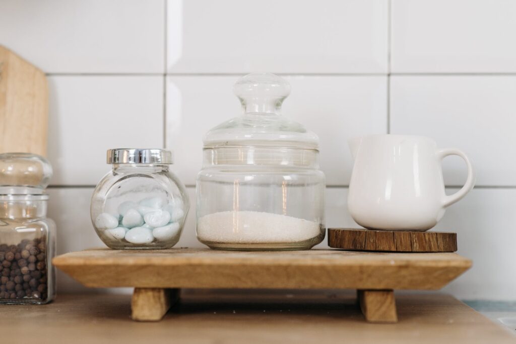 glass jars and ceramic cup on wooden coaster