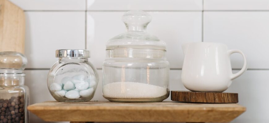 glass jars and ceramic cup on wooden coaster