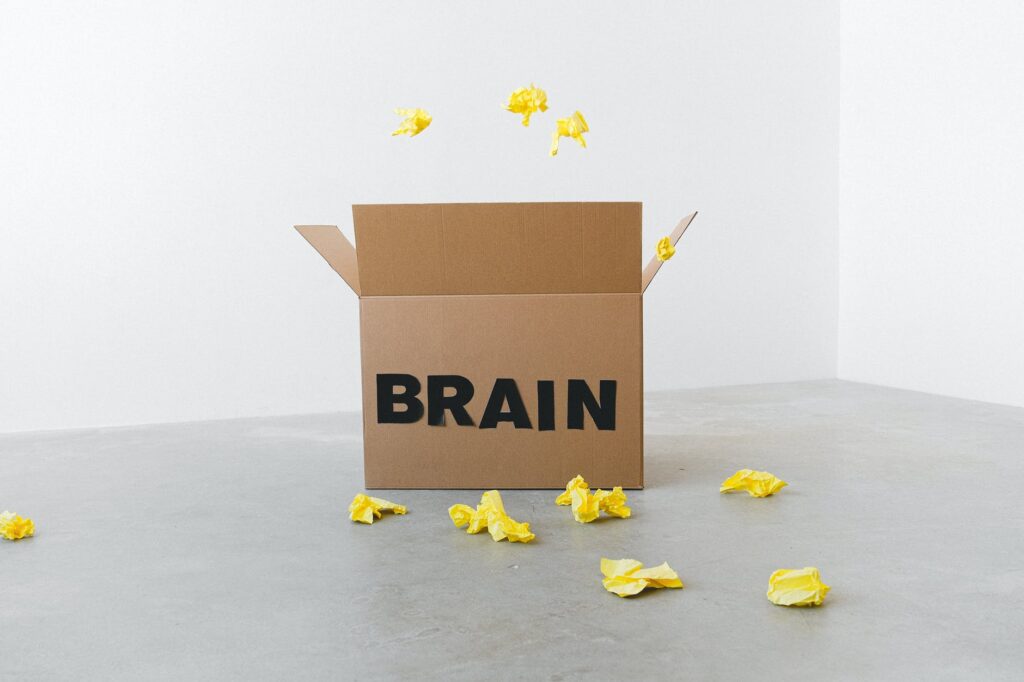brain inscription on cardboard box under flying paper pieces