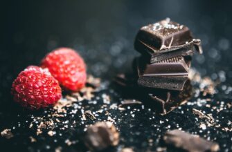 close up photo of stacked chocolates bars beside raspberries
