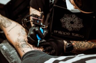 person in black leather gloves holding black and white textile