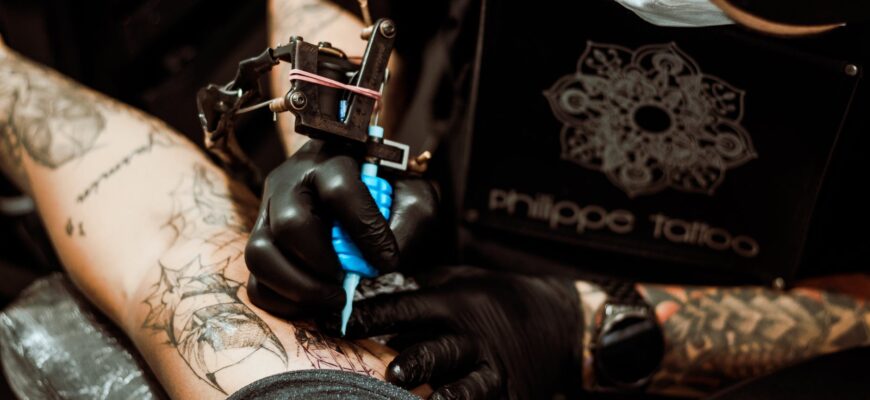 person in black leather gloves holding black and white textile