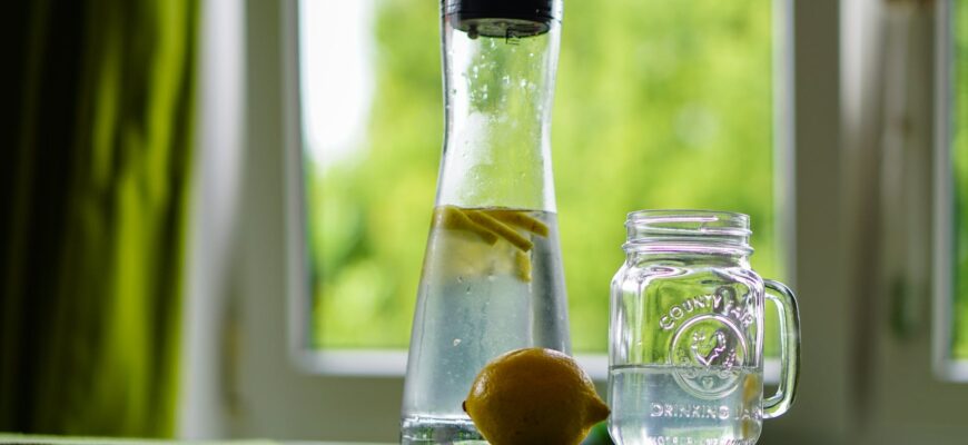 shallow focus photography of yellow lemon near glass mason jar and glass decanter