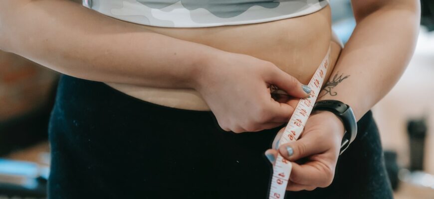plump woman in sportswear with measuring tape