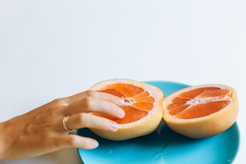 person touching sliced orange fruit