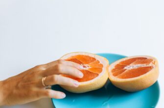 person touching sliced orange fruit
