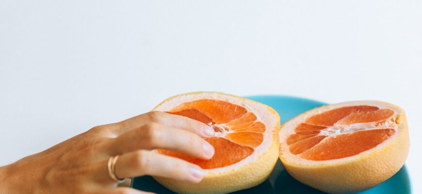 person touching sliced orange fruit
