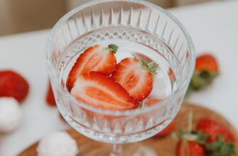 a clear glass with slices of strawberries in close up photography
