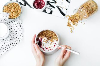 person mixing cereal milk and strawberry jam on white ceramic bowl