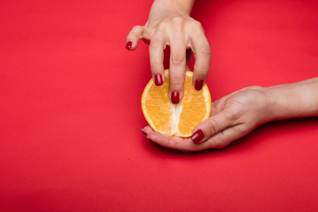 a person holding an orange fruit