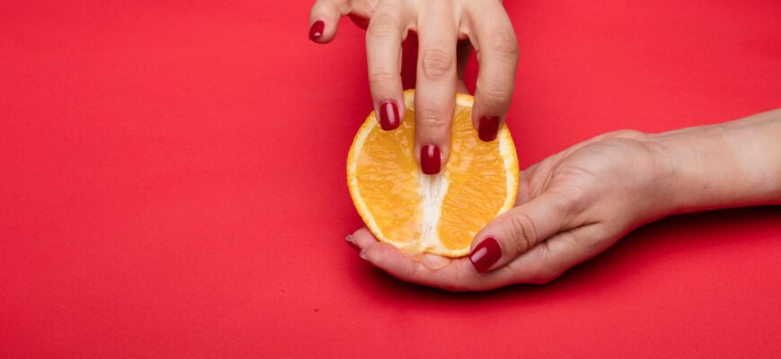 a person holding an orange fruit