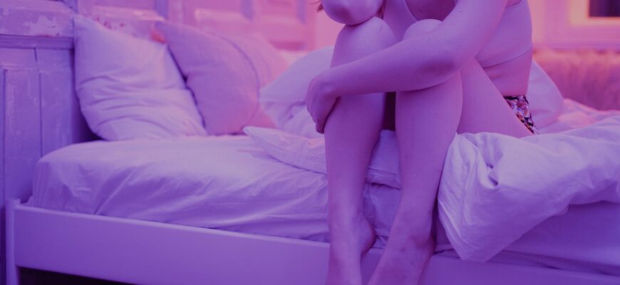 woman sitting on white bed