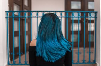 blue haired woman facing metal fence