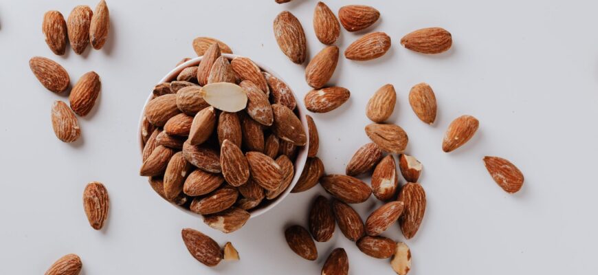 bowl filled with raw almond nuts on white background