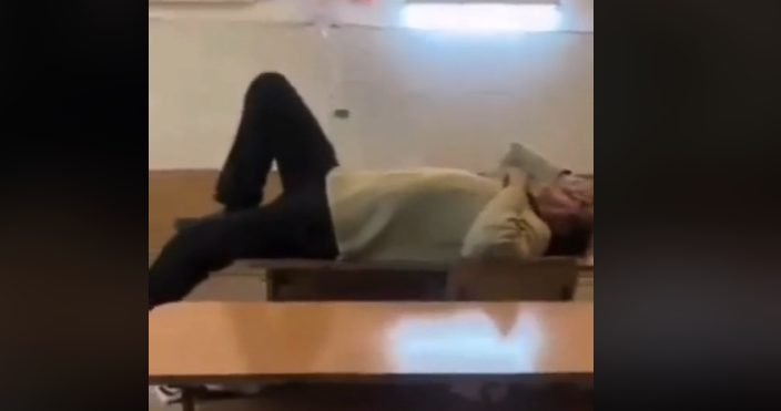 VIDEO// Un profesor a fost surprins în timp ce dormea întins pe masă, în timpul orelor: ”Domnule profesor, poate vreți un masaj?”
