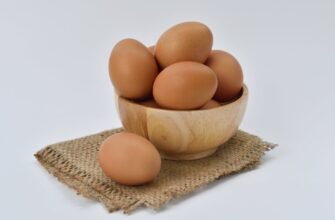 brown eggs on brown wooden bowl on beige knit textile