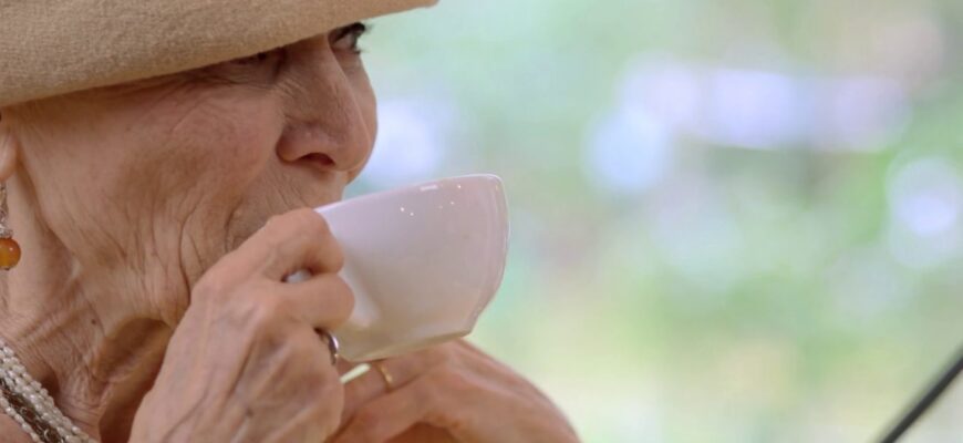 femeie in varsta bea cafea