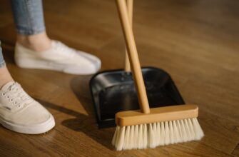 person wearing white pants and white socks standing beside brown broom