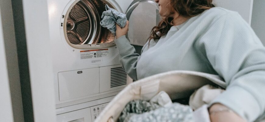 woman loading clothes in washing machine