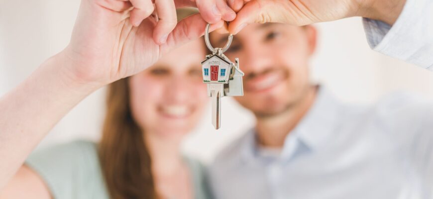 happy couple holding and showing a house key