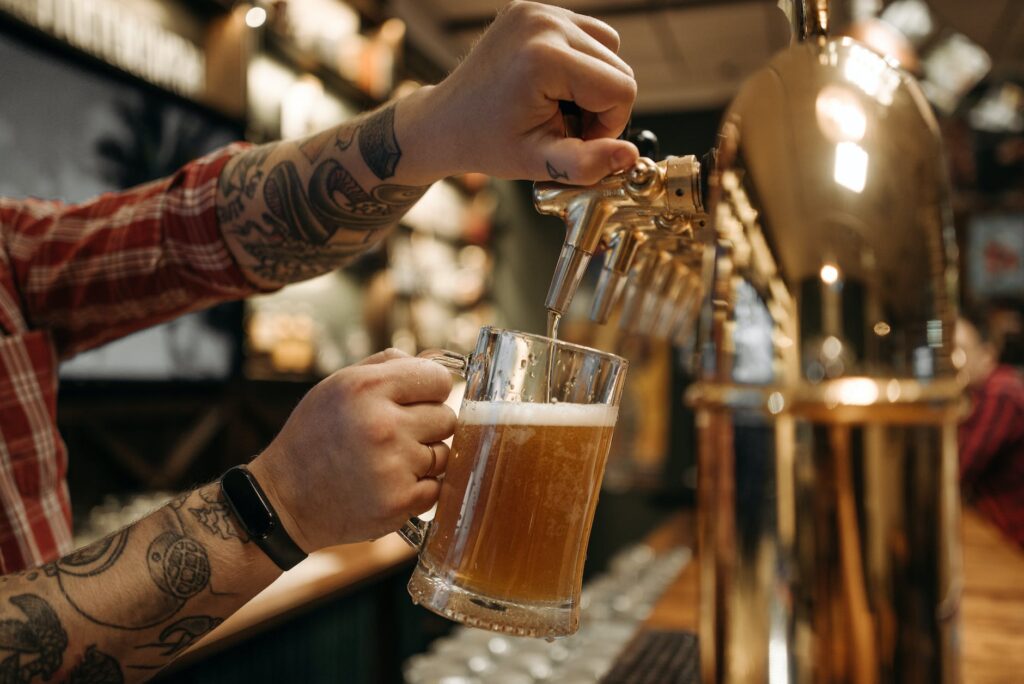 person holding clear drinking glass with beer