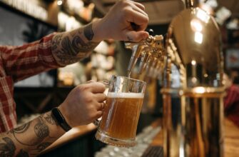 person holding clear drinking glass with beer