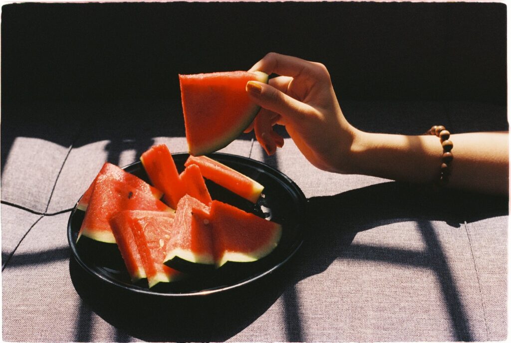 person picking sliced watermelon fruit