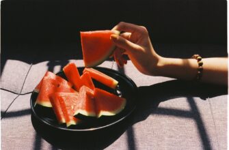 person picking sliced watermelon fruit