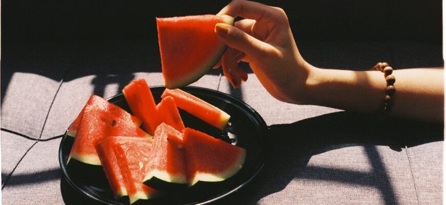 person picking sliced watermelon fruit
