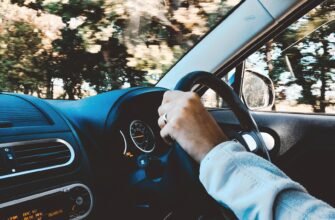person holding black vehicle steering wheel