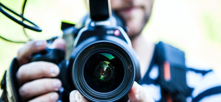 person holding canon dslr camera close up photo