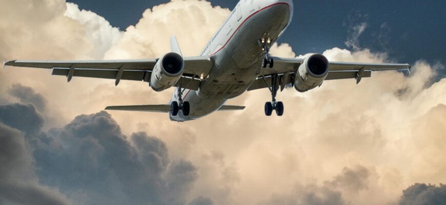 white and red plane beside clouds low angle photography