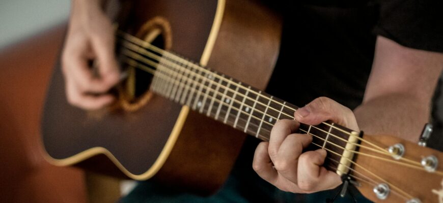 person playing brown guitar