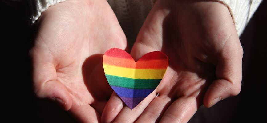 person holding multi colored heart shaped ornament