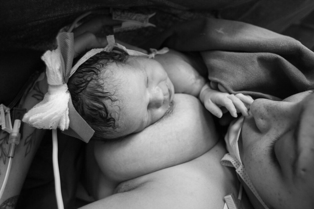woman having skin to skin contact with her newborn baby