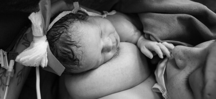 woman having skin to skin contact with her newborn baby